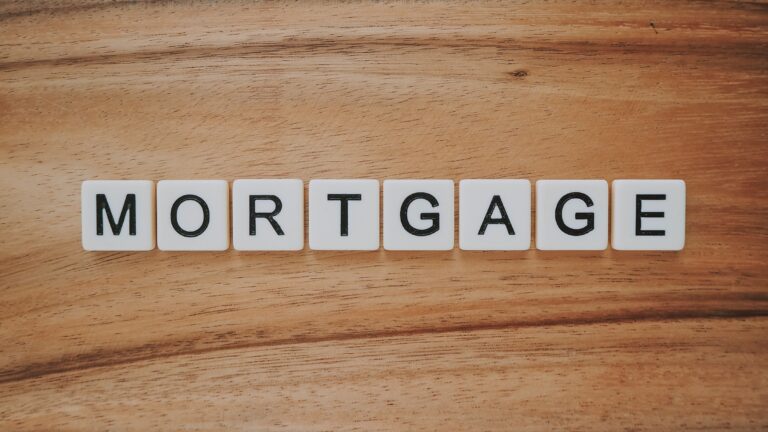 Letter tiles spelling Mortgage on a wooden surface.